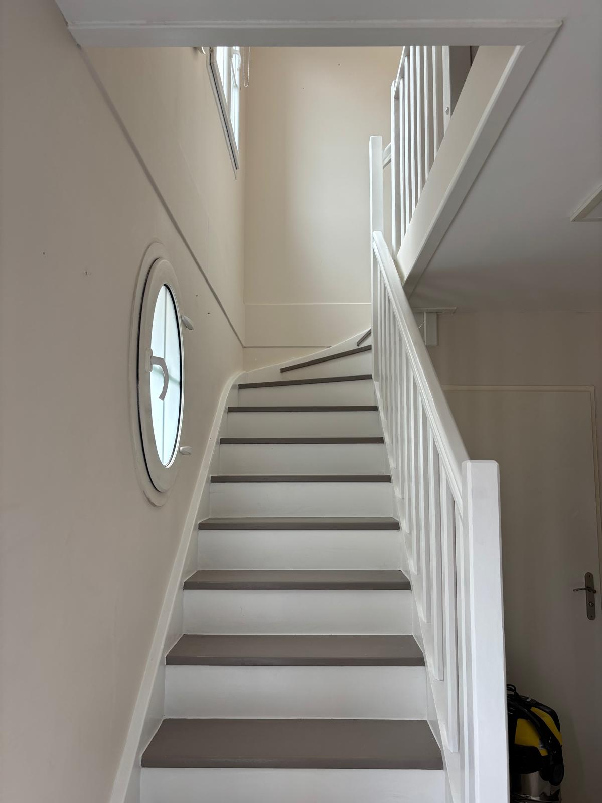 Escalier rénové à Bailly-Romainvilliers — marches vernies bicolores et garde-corps blanc
