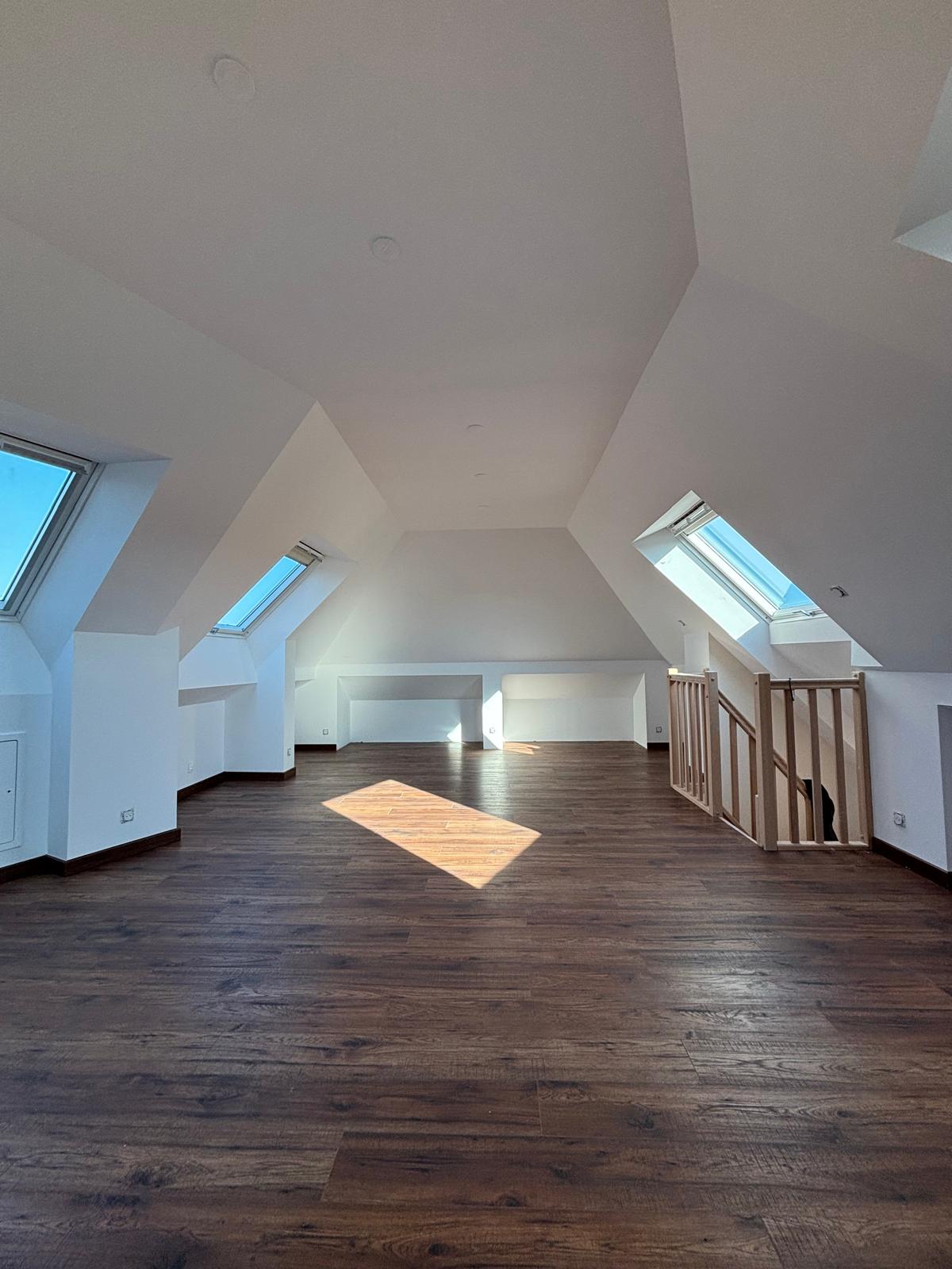 Comble aménagé à Magny-le-Hongre — parquet flottant bois foncé et peinture blanche