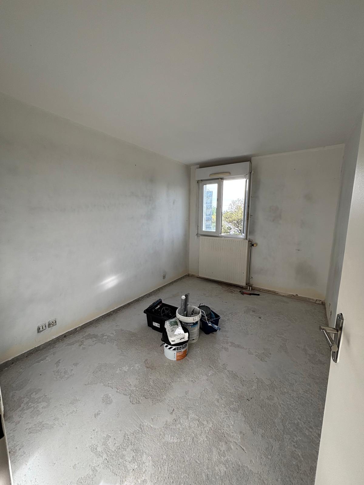 Chambre avant rénovation — murs tachés et sol en chape brute, appartement Torcy (77)