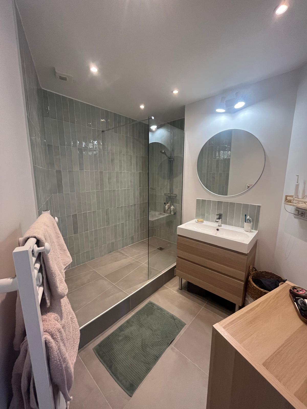 Salle de bain rénovée à Champigny-sur-Marne (94) — faïence verte céladon, douche à l'italienne, meuble vasque bois