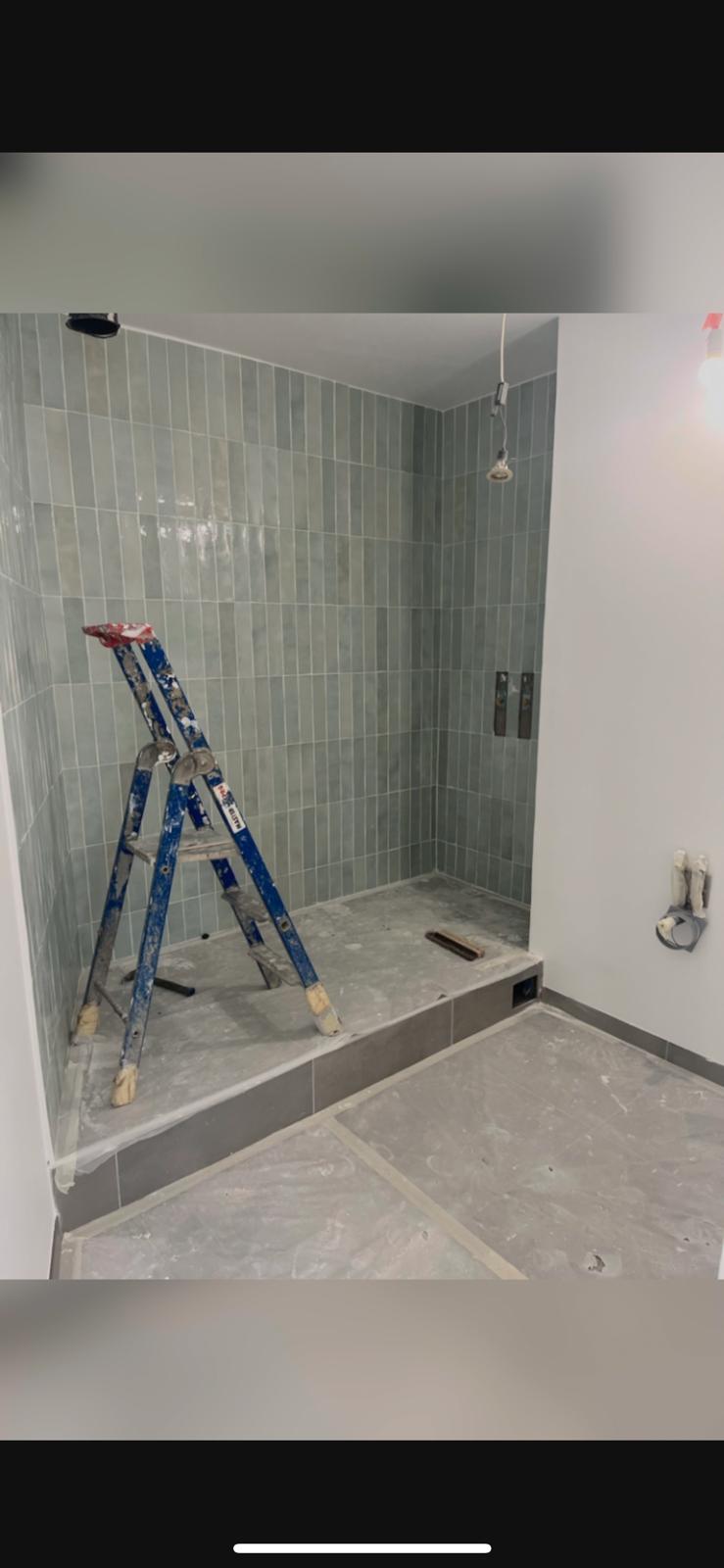 Salle de bain Champigny-sur-Marne — faïence verte céladon verticale en cours de pose dans la douche italienne