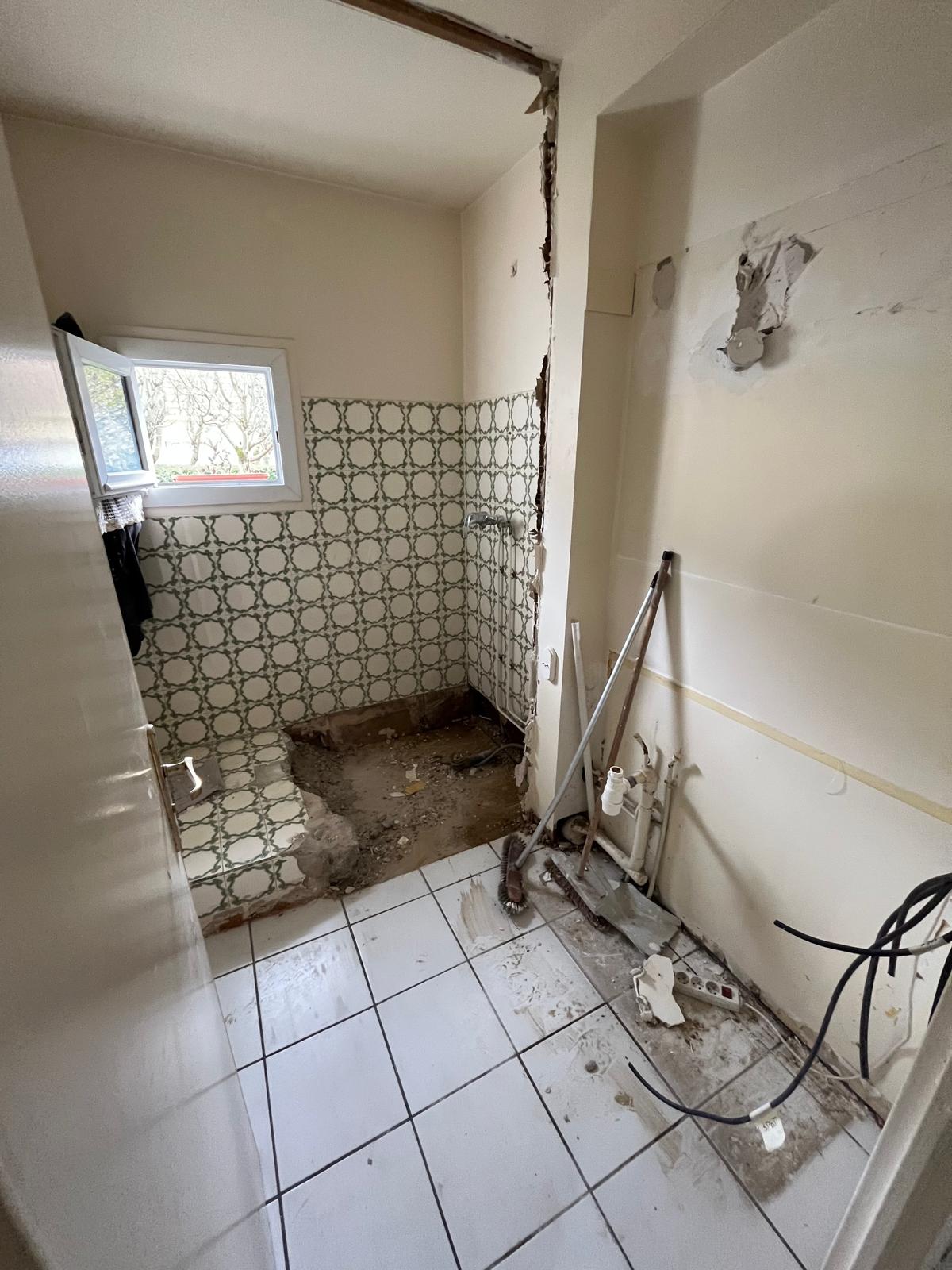 Salle de bain RDC pendant démolition — sol arraché, mise à nu, Collégien (77)