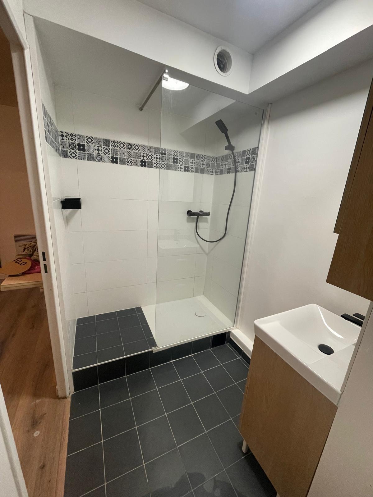 Salle de bain après rénovation — douche receveur blanc, carrelage gris anthracite, robinetterie noire, Noisy-le-Grand (93)