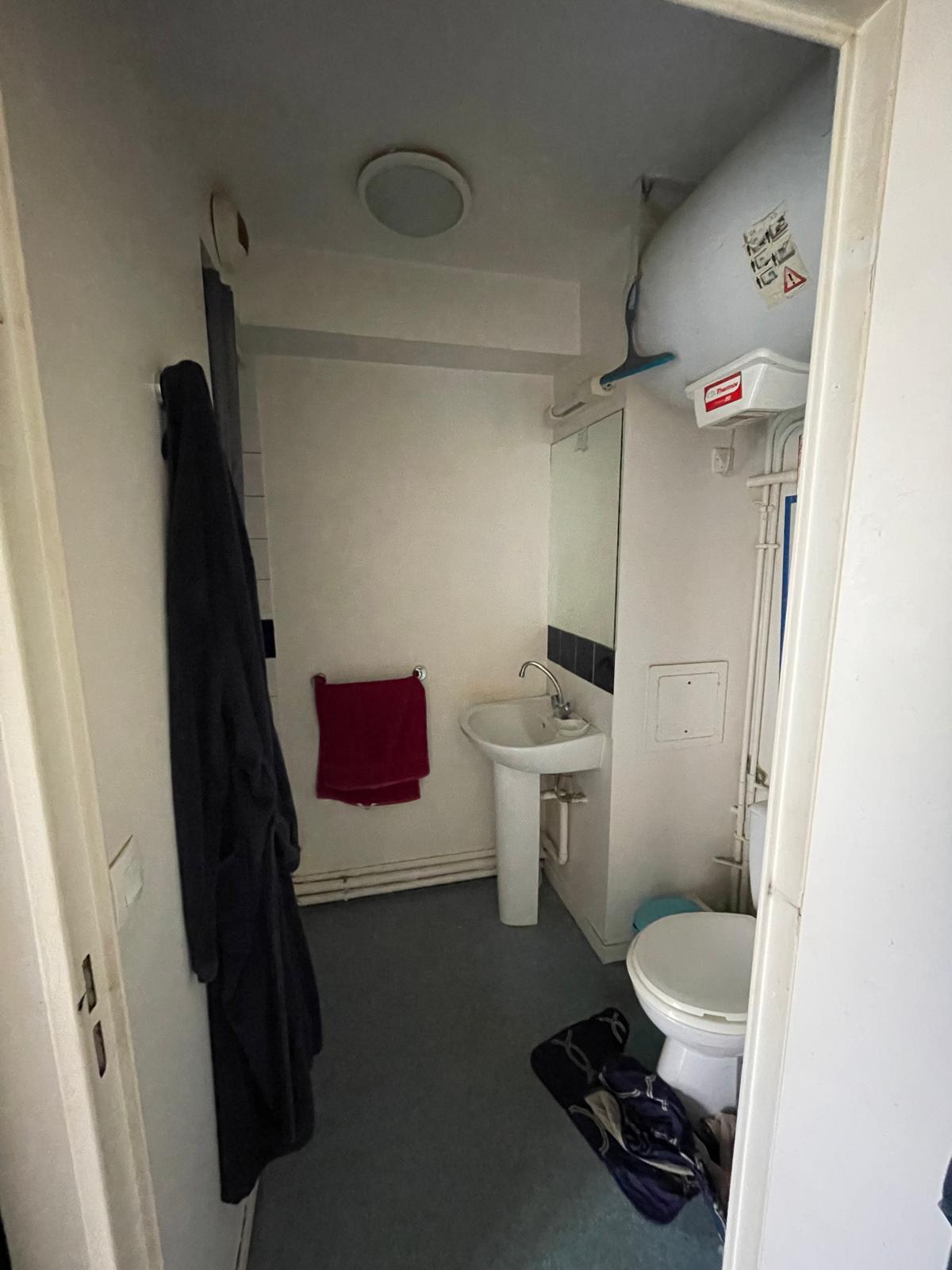 Salle de bain avant rénovation — état déplorable laissé par le locataire, lavabo sur pied, sol vinyle usé, studio Noisy-le-Grand (93)